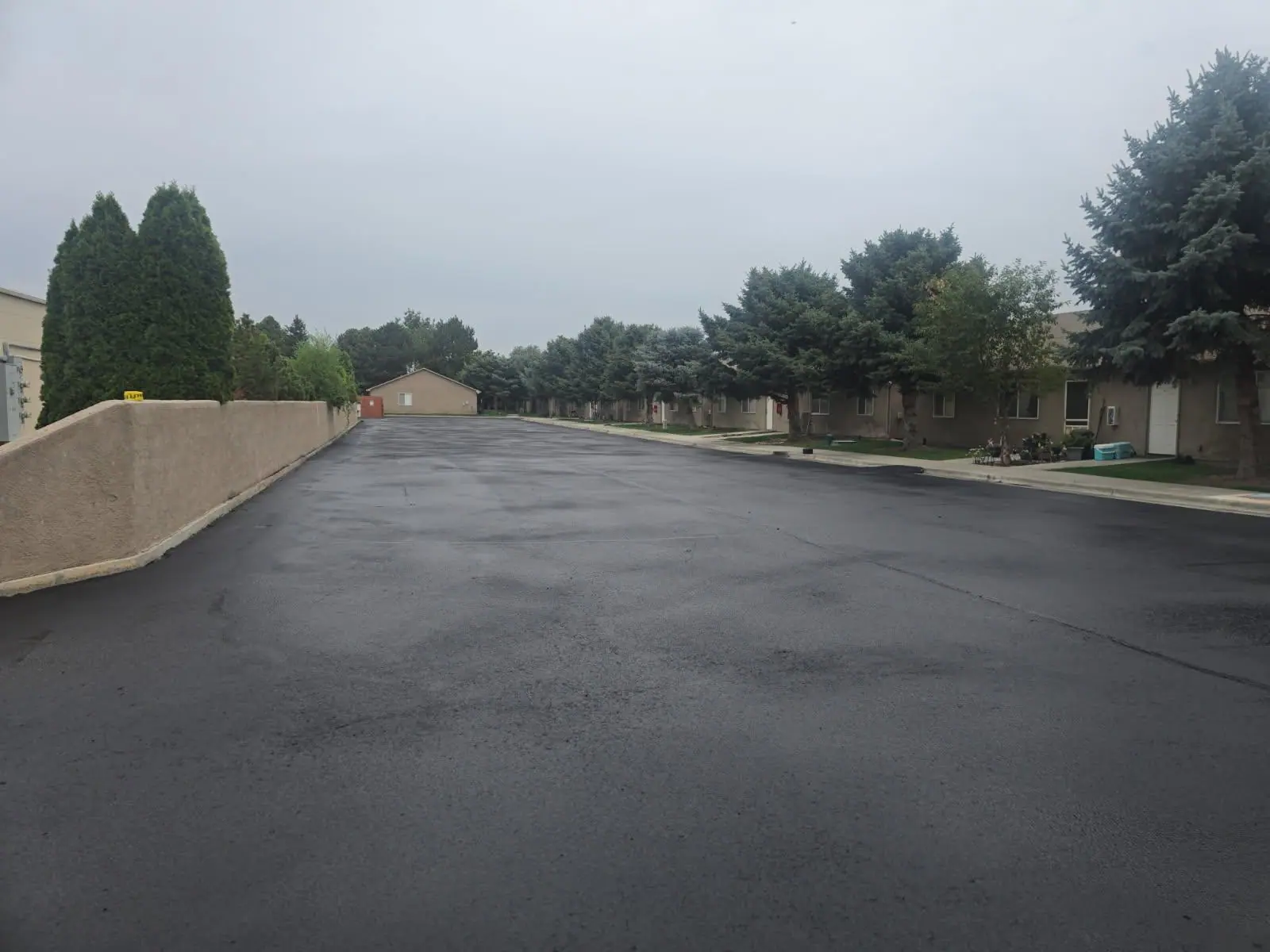 Freshly sealed black asphalt on an apartment complex parking lot