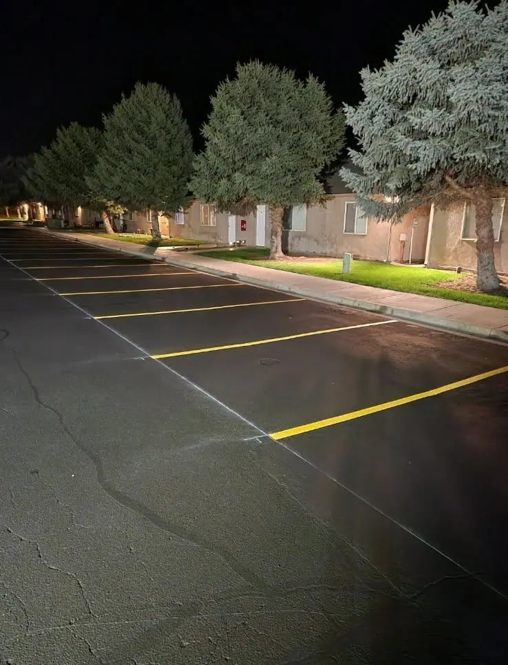 New yellow parking stall lines on dark asphalt at night
